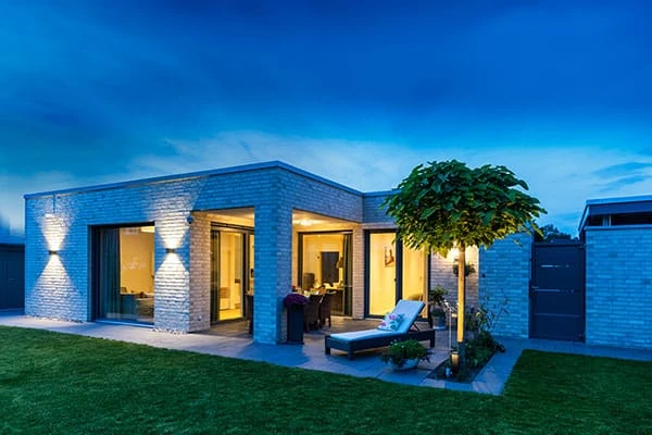 Esszimmer mit Esstisch und Stühlen, daneben Terrassentür zum Garten